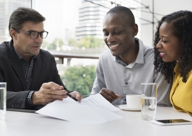 Couple sitting at table with Financial Advisor